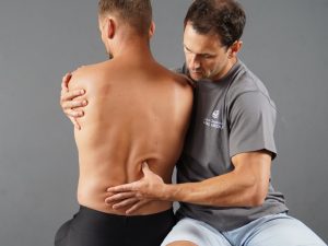 instruktor marcin walkowski bada studenta podczas kursu masazu tkanek glebokich